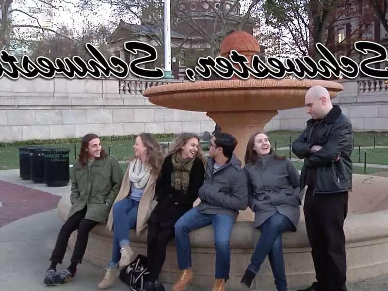 Several people sitting on the edge of an outdoor fountain